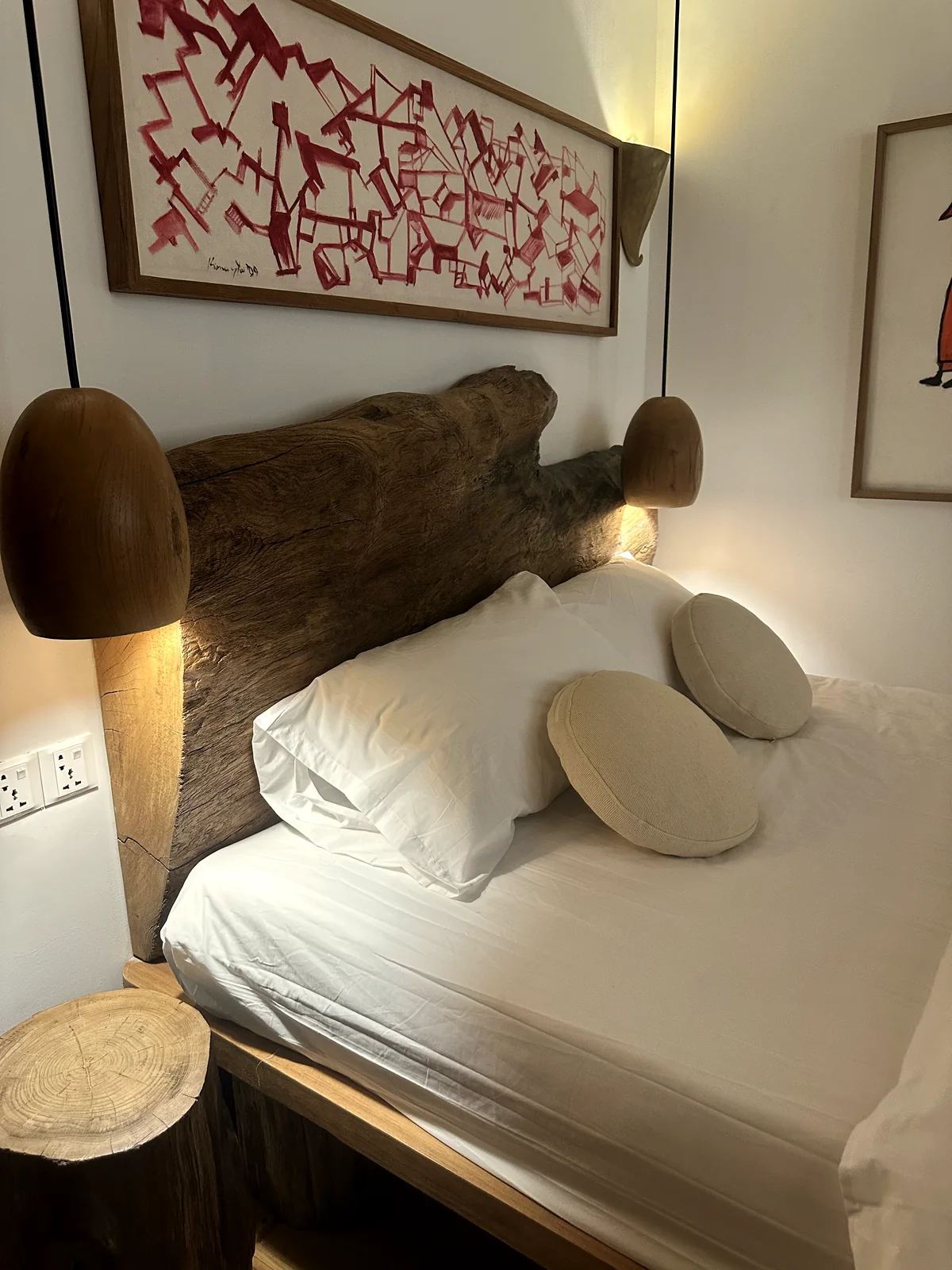 Bedroom with live-edge headboard and turned teak lamps